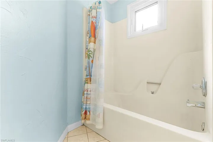 Full bathroom with shower / bath combo and tile patterned floors