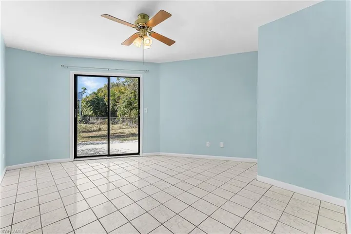 Empty room featuring a ceiling fan and light tile patterned floors