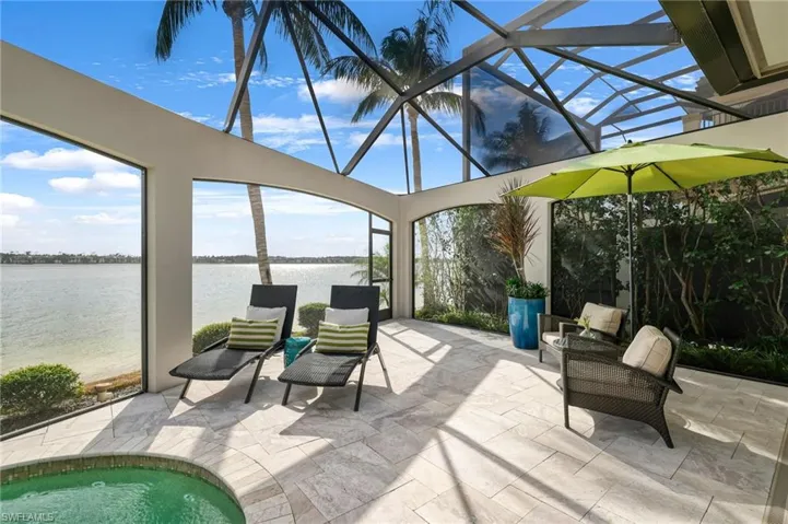 View of patio / terrace featuring glass enclosure and a water view