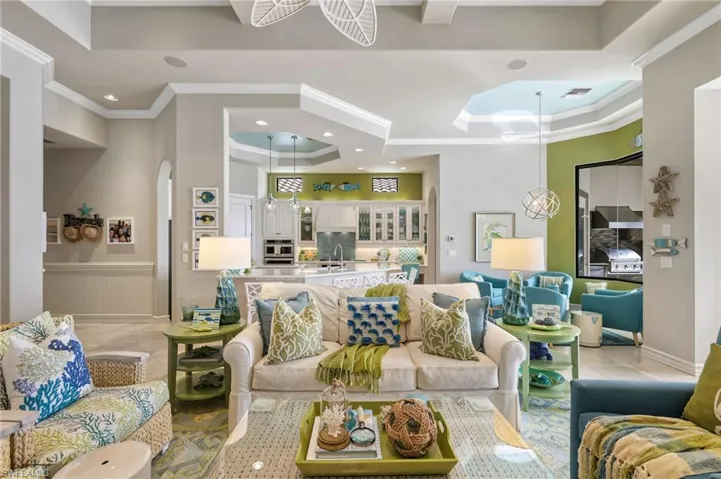 Tiled living room featuring ornamental molding, sink, and a tray ceiling