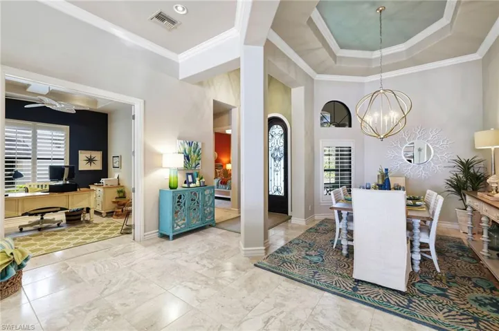Dining room featuring ceiling fan with notable chandelier, a wealth of natural light, and crown molding