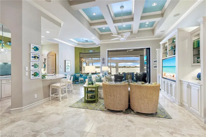 Living room with beamed ceiling, ceiling fan, ornamental molding, and coffered ceiling