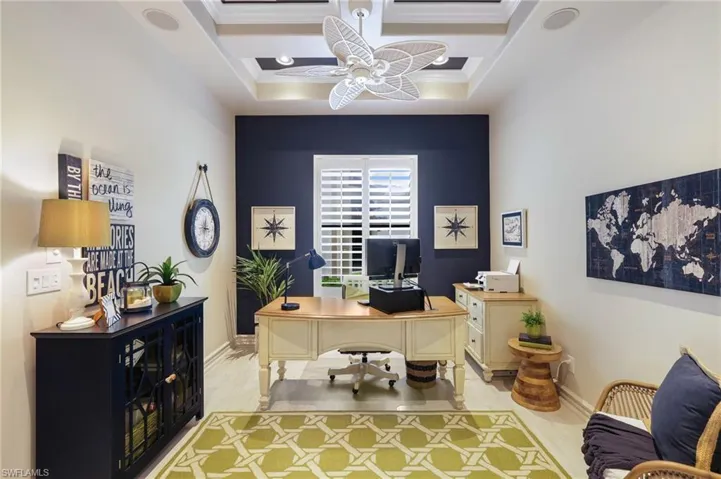 Office featuring a raised ceiling, crown molding, ceiling fan, and light wood-type flooring
