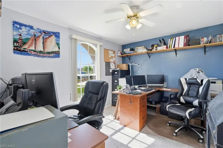 Office area with a ceiling fan and carpet