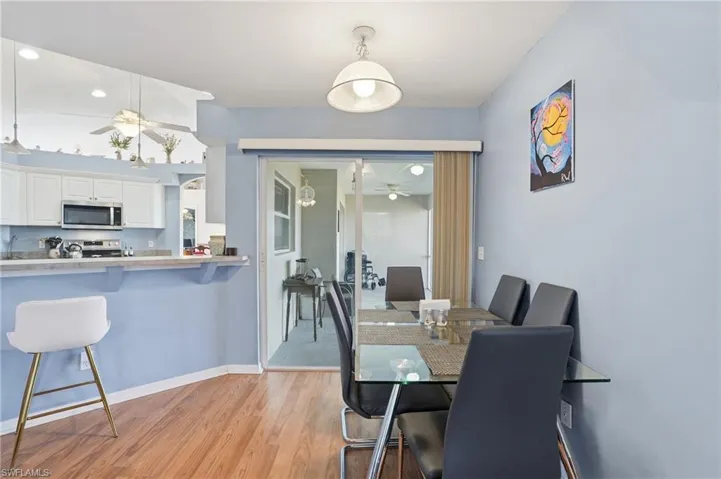 Dining space with ceiling fan and light wood-style flooring