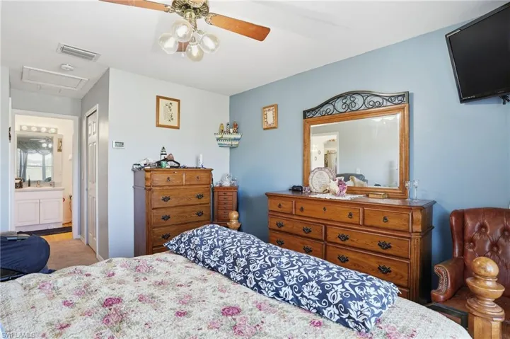 Bedroom featuring ensuite bathroom, ceiling fan, and a closet
