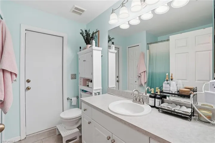 Full bath featuring vanity, a shower with curtain, and light tile patterned floors