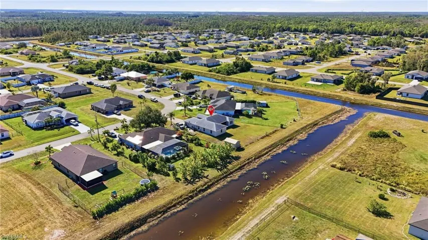 Aerial view of property's location featuring a large body of water and nearby suburban area
