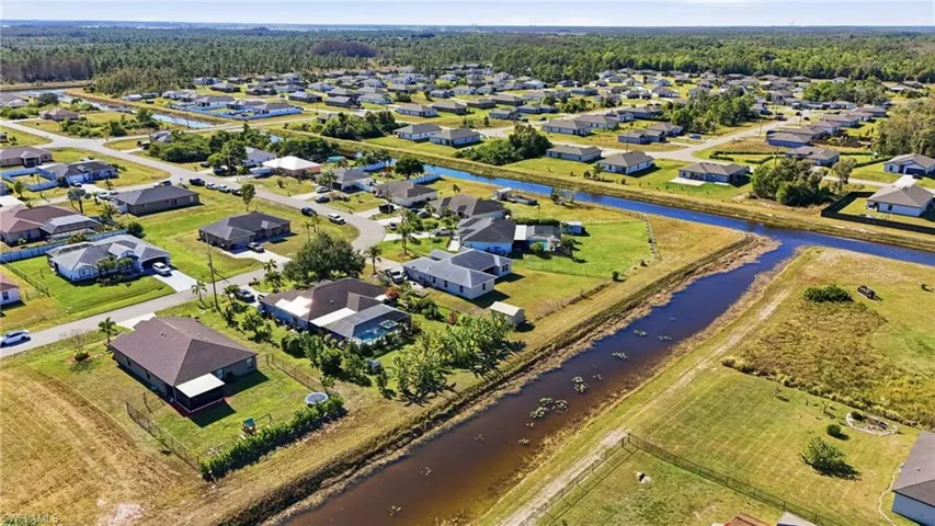 Aerial view of property and surrounding area featuring a large body of water and nearby suburban area