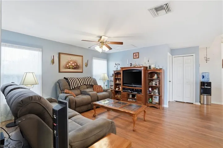 Living area featuring healthy amount of natural light, light wood-style flooring, and ceiling fan