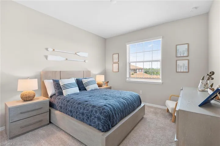 Bedroom with baseboards and light colored carpet