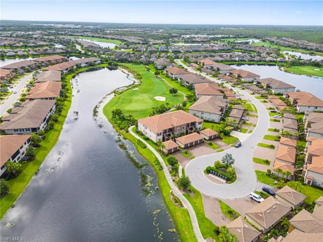 Aerial perspective of suburban area with a large body of water and a golf course