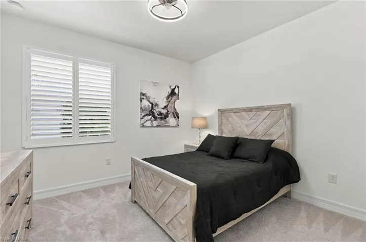 White walls, light gray carpet, and a modern ceiling fixture
