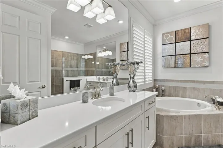 Dual vanity with integrated sinks, white cabinetry, and brushed nickel hardware