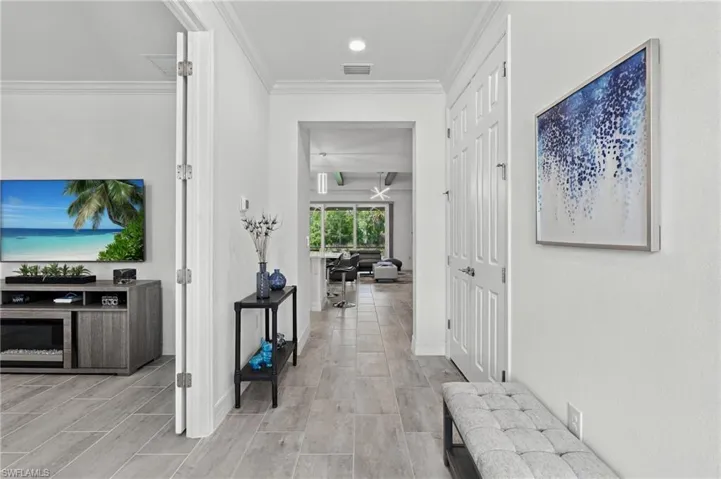 Wide-plank tile flooring, recessed lighting, and a white paneled door