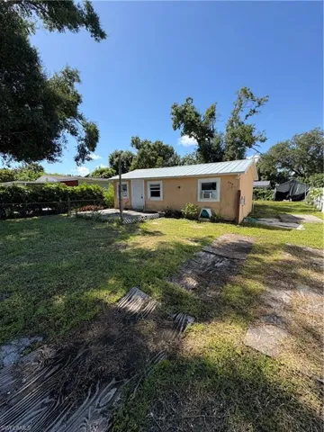 Back of property with a metal roof and stucco siding