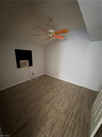Empty room featuring a ceiling fan and baseboards