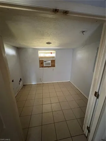 Unfurnished room with a textured ceiling and tile patterned floors