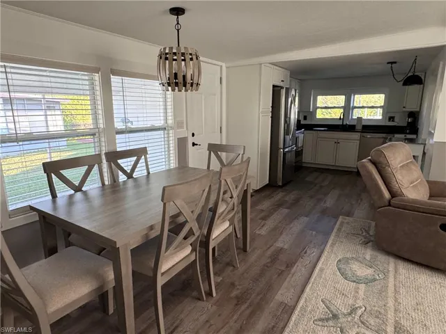 Dining space with dark wood-style flooring and a chandelier