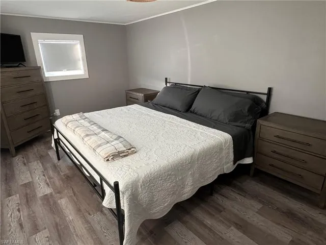 Bedroom with light wood-style flooring and ornamental molding