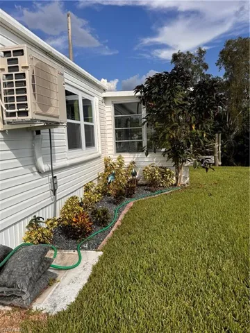 View of home's exterior with a lawn and a cooling unit