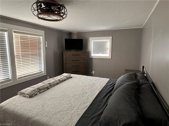Bedroom with a textured ceiling and crown molding