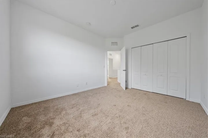 Unfurnished bedroom with a closet and light colored carpet