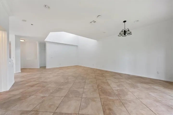 Spare room with an inviting chandelier and ornamental molding