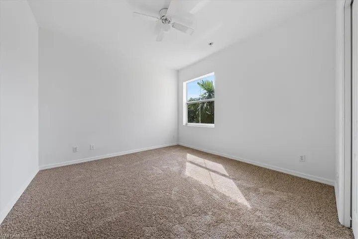 Empty room with ceiling fan and carpet