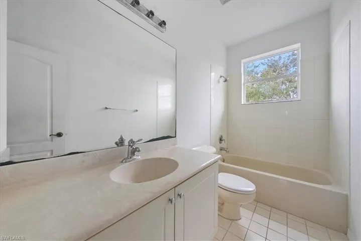 Full bathroom featuring tile patterned floors, vanity, toilet, and tiled shower / bath combo