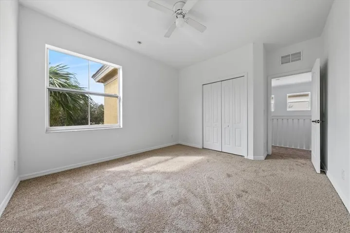 Unfurnished bedroom featuring light carpet, a closet, and ceiling fan