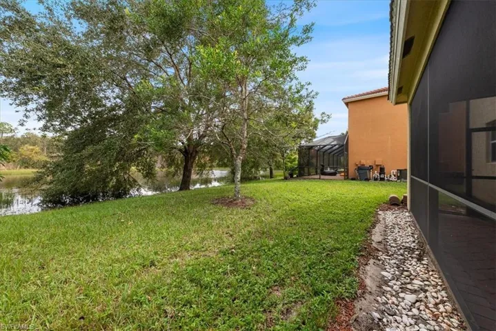 View of yard featuring a lanai and a water view