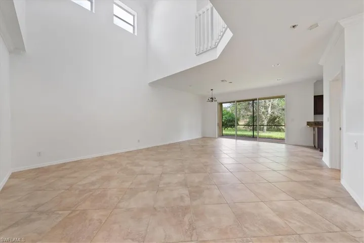 Unfurnished living room with a towering ceiling and light tile patterned floors