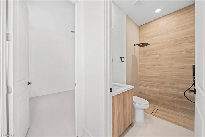 Bathroom with vanity, a tile shower, and recessed lighting