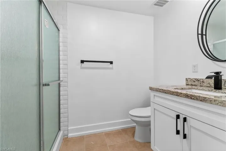 Bathroom featuring vanity, a shower stall, and light tile patterned floors