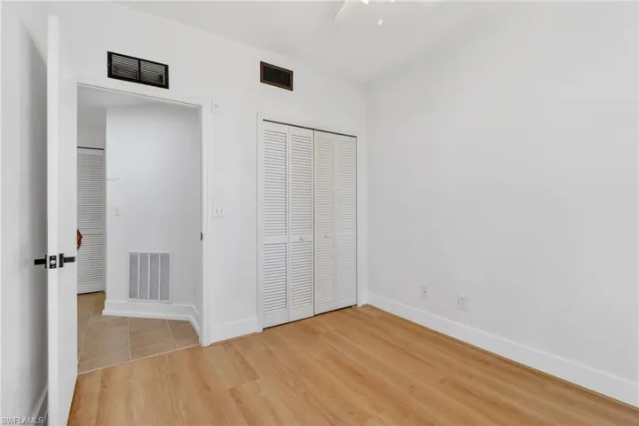 Unfurnished bedroom with light wood-type flooring, a closet, and a ceiling fan
