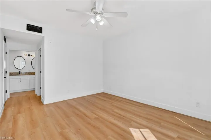Unfurnished bedroom featuring light wood-style floors, a ceiling fan, and connected bathroom
