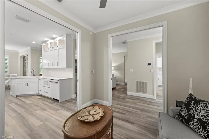 Bathroom featuring vanity, decorative backsplash, hardwood / wood-style flooring, and crown molding