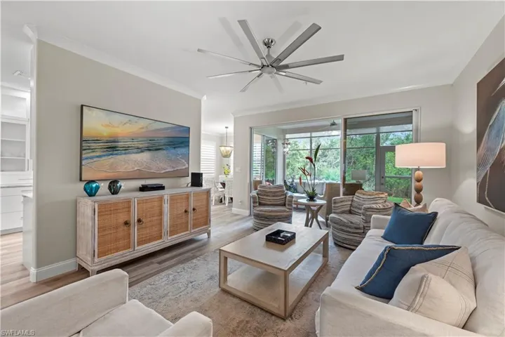 Living room featuring hardwood / wood-style flooring, ceiling fan, and ornamental molding