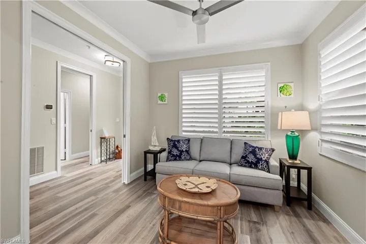 Living room featuring ceiling fan, light hardwood / wood-style flooring, and crown molding