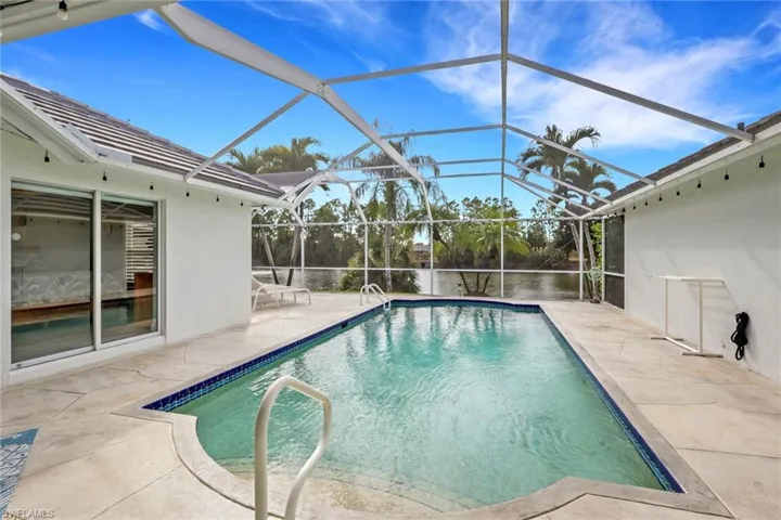 Swimming pool featuring a patio, a lanai, and a sunroom