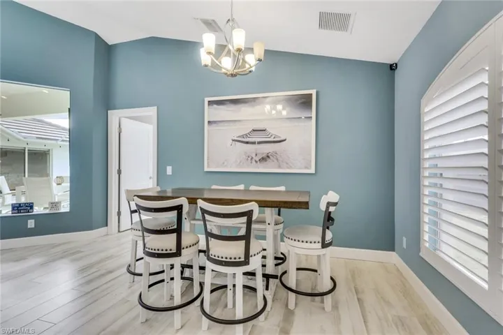 Dining space with light wood-style floors, lofted ceiling, and hanging lights
