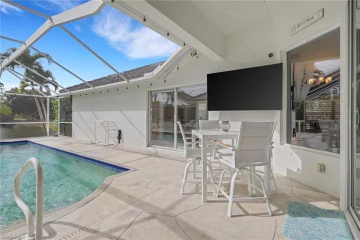 Outdoor pool with a patio area, a sunroom, a lanai, and outdoor dining area
