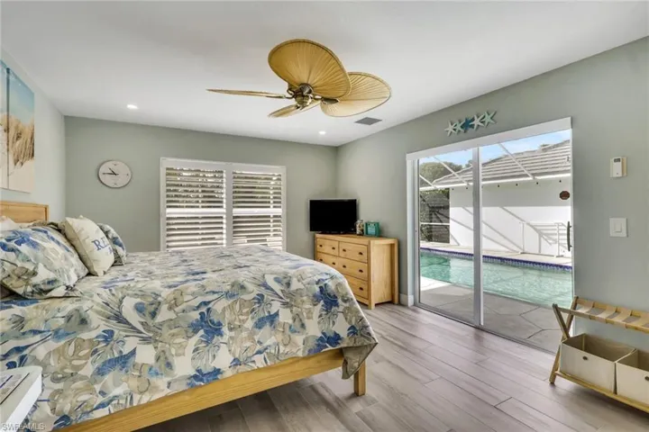Bedroom with access to exterior, wood finished floors, ceiling fan, and recessed lighting