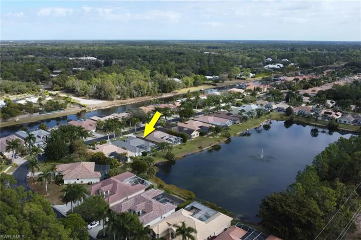 Aerial view of property and surrounding area featuring nearby suburban area and a nearby body of water