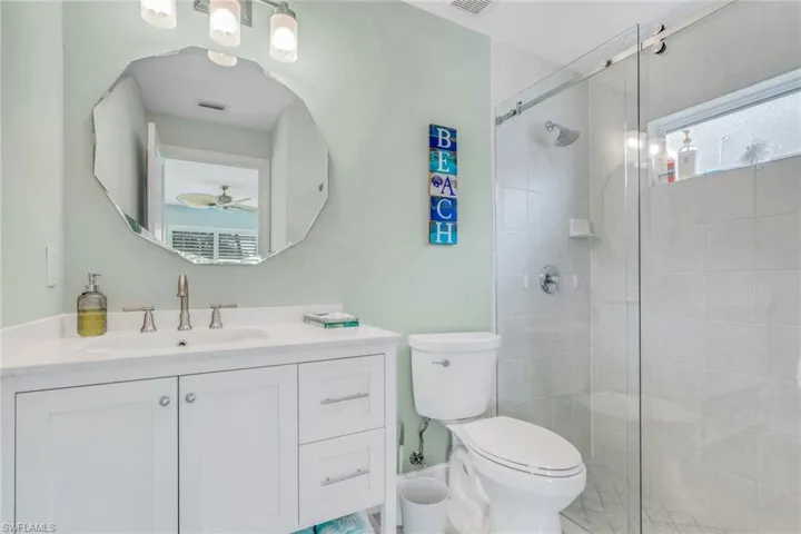 Full bathroom featuring vanity, a stall shower, and ceiling fan