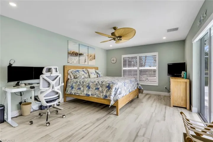 Bedroom with access to exterior, a desk, a ceiling fan, recessed lighting, and wood finished floors