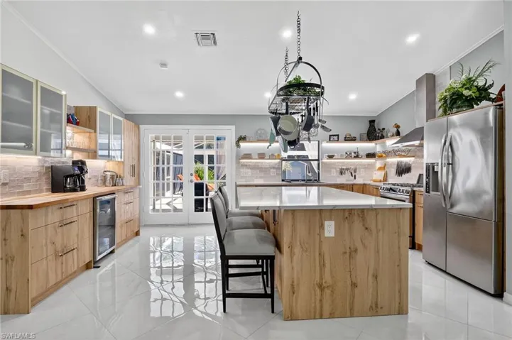 Light and bright kitchen with abundant storage including storage under bar stool area.