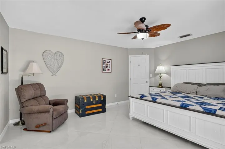 Master bedroom with ceiling fan, two closets and marble floors.
