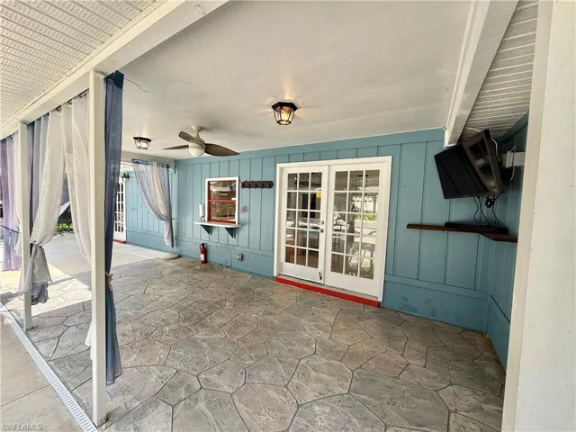 Covered back porch with outdoor TV, sliding window to kitchen.
